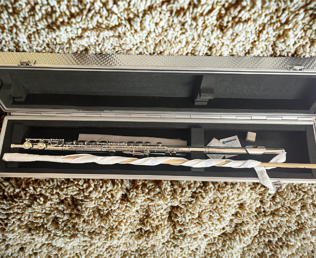 FLIC wand and ribbon swab set displayed with a flute